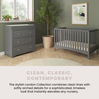 A modern nursery featuring the Child Craft Harmony 3-Drawer Dresser with Changing Table Topper in Cool Gray, a matching gray crib, green walls, potted plant, and window blinds. The London Collection offers clean lines and timeless style.