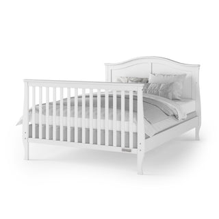 The Child Craft F06454 Full-Size Bed Rails in matte white are shown with a white wooden bed frame, vertical slat footboard, gray and white bedding, and pillows, all displayed against a plain white background.
