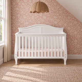 Matte White Child Craft Camden 4-in-1 Convertible Crib with an arched headboard, slatted sides, and a pink mattress.