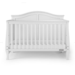 The Child Craft Camden 4-in-1 Convertible Crib in Matte White features a curved headboard, vertical slats, and a fitted mattress, shown from the front on a plain white background for lasting versatility.