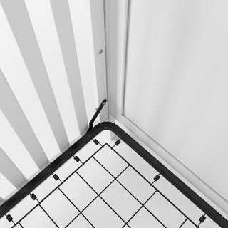 Close-up of the corner of a Child Craft Camden 4-in-1 Convertible Crib in Matte White, featuring a grid structure and placed against white paneled walls.