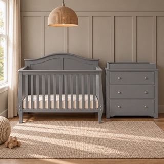 A cool grey Camden 4-in-1 Convertible Crib and matching three-drawer dresser with a changing top in a nursery.