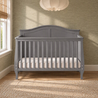 Child Craft Camden 4-in-1 Convertible Crib in cool grey with a curved headboard and a white mattress.