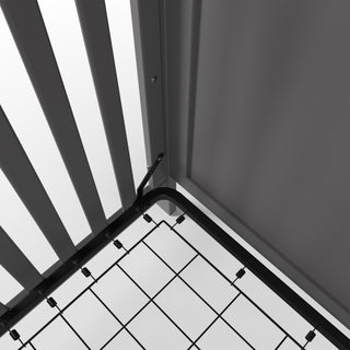 Close-up of the Camden 4-in-1 Convertible Crib by Child Craft in Cool Grey, showing its metal bed frame with grid support, slats, screws, and modern details assembled near a wall and floor.