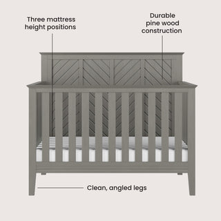 Front view of the Child Craft Atwood 4-in-1 Convertible Crib in Lunar Gray shows a chevron-patterned headboard, clean angled legs, durable pine wood construction, and three adjustable mattress heights.
