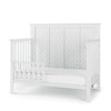 The Child Craft Toddler Guard Rail in Matte White features sturdy wood construction, a chevron-patterned headboard, partial side panels, and an open front, shown on a white background.