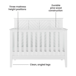 Front view of the Child Craft Atwood 4-in-1 Convertible Crib in matte white, showing labeled features: three mattress height positions, sturdy pine wood build, clean angled legs, and a chevron-patterned back panel.