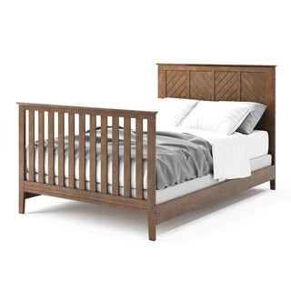 The Child Craft Atwood 4-in-1 Convertible Crib in Cocoa Bean features a slatted footboard and patterned headboard, shown with white bedding and a gray blanket for a neat, stylish look.