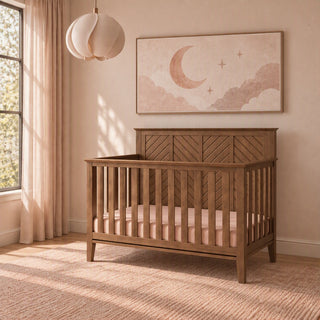 Cocoa Bean Child Craft Atwood 4-in-1 Convertible Crib with a herringbone-patterned headboard, featuring a pale pink mattress sheet and baby-safe finishes.