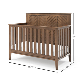 The Child Craft Atwood 4-in-1 Convertible Crib in Cocoa Bean features a chevron-patterned headboard, vertical side slats, and comes with a white mattress. Dimensions: 47" H x 55.75" W x 30" D.