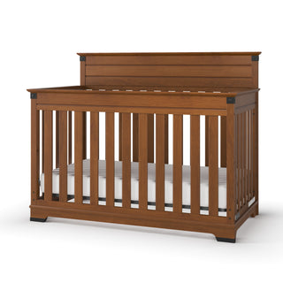 A Child Craft Redmond 4-in-1 Convertible Crib in Coach Cherry, featuring vertical slats and a high solid headboard with a white mattress, is displayed against a plain white background.