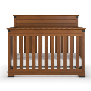 The Child Craft Redmond 4-in-1 Convertible Crib in Coach Cherry features vertical slats, a high back panel, and a white mattress, all displayed against a plain white background.