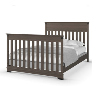 The Child Craft F06474 Full-Size Bed Rails in Dapper Gray feature sturdy construction and classic vertical slats, paired with white sheets, pillows, and a gray blanket—perfect for a timeless bedroom look.