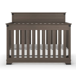 The Child Craft Redmond 4-in-1 Convertible Crib in Dapper Gray features vertical slats on all sides and a solid headboard, shown with a white mattress inside, set against a plain white background.