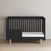 A sleek Child Craft crib with black and gray tones, wooden legs, and an airy side panel stands on a light wood floor. A plain white mattress fits inside, ideal to pair with the Child Craft F09505 Toddler Guard Rail in Caviar Black as your child grows.