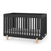 The Park Heights 4-In-1 Euro Crib by Child Craft features a sleek caviar black finish, vertical slats, light wooden legs, and a white mattress. Crafted from Brazilian hardwood, it adds minimalist, mid-century style and heirloom quality to any nursery.