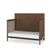 The Child Craft Kieran 4-in-1 Convertible Crib in Toasted Chestnut features a modern herringbone-patterned headboard, open slatted sides, and a white mattress with a minimalistic dark brown finish.