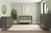 A modern nursery with sage green walls, Child Craft's Cranbrook 4-in-1 Convertible Crib in Lunar Gray, coordinated gray nursery furniture and changing table, a large potted plant, abstract art, and a white rug on wood flooring.