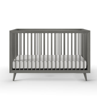 The Child Craft Cranbrook 4-in-1 Convertible Crib in Lunar Gray features modern vertical slats and a white mattress, creating a stylish nursery centerpiece against a clean white background.