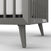 Close-up of the Child Craft Cranbrook 4-in-1 Convertible Crib in Lunar Gray, featuring tapered legs, vertical slats, and visible mattress. Two metal safety labels are attached to the frame—ideal nursery furniture for a stylish space.