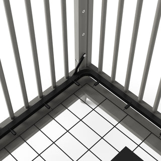 A close-up of the Child Craft Cranbrook 4-in-1 Convertible Crib in Lunar Gray shows metal railing-like vertical bars on a tiled floor, with black wiring held by clips along the base, echoing mid-century modern style.