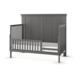 The Child Craft F09503 Toddler Guard Rail in Midnight Gray features slatted sides, a high solid headboard, and a low guard rail—ideal for crib-to-bed transitions using an easy crib conversion kit. Includes white mattress.