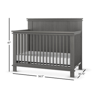 The Child Craft Denman 4-in-1 Convertible Crib in Midnight Gray features vertical slats, a solid back panel, a white mattress, and measures 47"H x 56.5"W x 30.75"D, with measurement lines visible in the image.