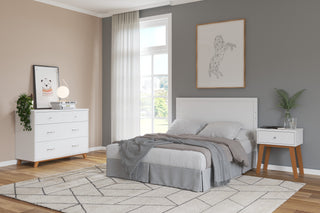 A modern bedroom with a bed, gray bedding, white headboard, a Child Craft Soho Nightstand in white/natural with a plant, a dresser with a mirror, lamp, books, geometric lion wall art, and a large window bringing in natural light.