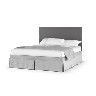 The Child Craft Soho 4-in-1 Flat Top Convertible Crib in Cool Gray features clean lines with a gray headboard, white bedding, and a light gray blanket, evoking mid-century modern style against a plain white background.