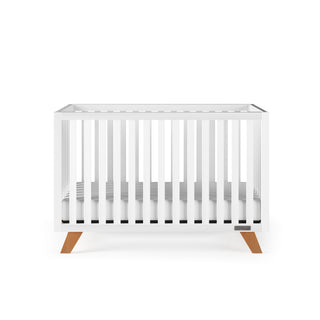 The Child Craft Soho 4-in-1 Convertible Crib in White/Natural features modern vertical slats, a flat top, and angled wooden legs, shown against a plain white background.