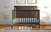 The Child Craft Scout 4-in-1 Convertible Crib in Dapper Gray features a beadboard headboard, gentle arch, and vertical slats. Converts from crib to toddler bed, day bed, and full bed. Scout 4-in-1 Crib branding appears at the bottom.