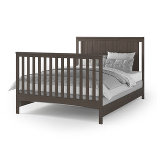 The Child Craft F06401 Full-Size Bed Rails in Dapper Gray are shown with a dark wood bed frame featuring vertical slats on the headboard and footboard, neatly made with white and gray bedding and several pillows.