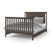 The Child Craft F06401 Full-Size Bed Rails in Dapper Gray are shown with a dark wood bed frame featuring vertical slats on the headboard and footboard, neatly made with white and gray bedding and several pillows.