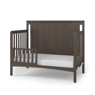 The Child Craft Scout 4-in-1 Convertible Crib in Dapper Gray features a solid panel headboard, slatted sides, and partial safety rail—ideal for transitioning from a convertible crib in your baby nursery.