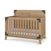 The Child Craft Lucas 4-in-1 Convertible Crib in Nutmeg features vertical slats, a high back panel, black metal corner accents, and a white mattress. The crib is empty and set against a white background.