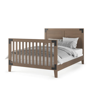 The Child Craft F06464 Full-Size Bed Rail in Dusty Heather features a solid headboard, slatted footboard, dark metal corner accents, and built-in rails for safety. Shown with gray and white bedding and pillows.