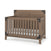 The Child Craft Lucas 4-in-1 Convertible Crib in Dusty Heather features vertical slats, dark metal corner brackets, a solid panel headboard, and comes with a white mattress inside.