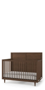 The Child Craft Surrey Hill 4-in-1 Convertible Crib in Toasted Chestnut features vertical slats on the sides and front, a solid back panel, and comes with a white mattress inside.