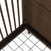 Close-up of the Surrey Hill 4-in-1 Convertible Crib by Child Craft in Toasted Chestnut, featuring a dark wooden corner with vertical slats, a solid headboard, and a metal mattress support grid held by a black zip tie.