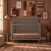 Lunar Gray Child Craft Surrey Hill 4-in-1 convertible crib with a paneled headboard, set against a terracotta wall decorated with framed artwork.