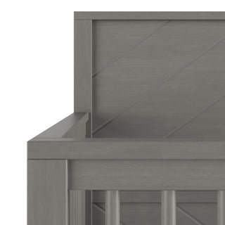 A close-up of the Surrey Hill 4-in-1 Convertible Crib by Child Craft in Lunar Gray highlights the headboard's diagonal grooves and vertical slats.
