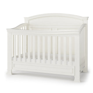 The Child Craft Westgate 4-in-1 Convertible Crib in Vintage Linen features slatted sides, an arched back panel, and adjustable mattress support, shown against a plain white background.