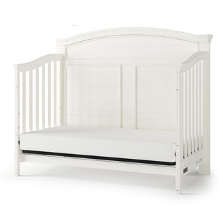 The Child Craft Westgate 4-in-1 Convertible Crib in Vintage Linen features slatted sides, an arched headboard, adjustable mattress support, and a sturdy pine frame for comfort and safety.