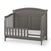 A Child Craft Chelsea Grey crib with the F09554 Toddler Guard Rail converts to a toddler bed, featuring an arched headboard, side rails, white mattress, and vertical slats for safety and timeless style.