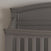 Close-up of the Child Craft Westgate 4-in-1 Convertible Crib in Chelsea Grey, featuring a dark pine wood headboard with decorative moldings and vertical slats, blending timeless design and lasting durability against a light wall.