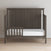 A dark wood toddler bed from Child Craft features strong construction, a high slatted headboard, the F09501 Dapper Gray Toddler Guard Rail, and a white mattress, set on a light wood floor against a plain wall.