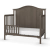 The Child Craft F09501 Toddler Guard Rail in Dapper Gray features sturdy wood construction, slatted sides, and a low front rail—ideal for converting your crib into a safe toddler bed.