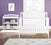 The Child Craft Arch Top Baby Changing Table in matte white stands with a matching crib against a purple nursery wall with hardwood floors, a gray patterned rug, and a framed flower print above the changing table.