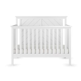 The Child Craft Hampton Flat Top 4-in-1 Convertible Crib in Matte White features solid pine wood construction, vertical slats, a chevron-patterned headboard, and adjustable mattress support, shown against a plain white background.