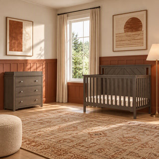 Child Craft Hampton Flat Top 4-in-1 Convertible Crib in Dapper Gray, featuring a gray slatted design and flat top, alongside a matching three-drawer dresser in a nursery with an area rug and wall art.